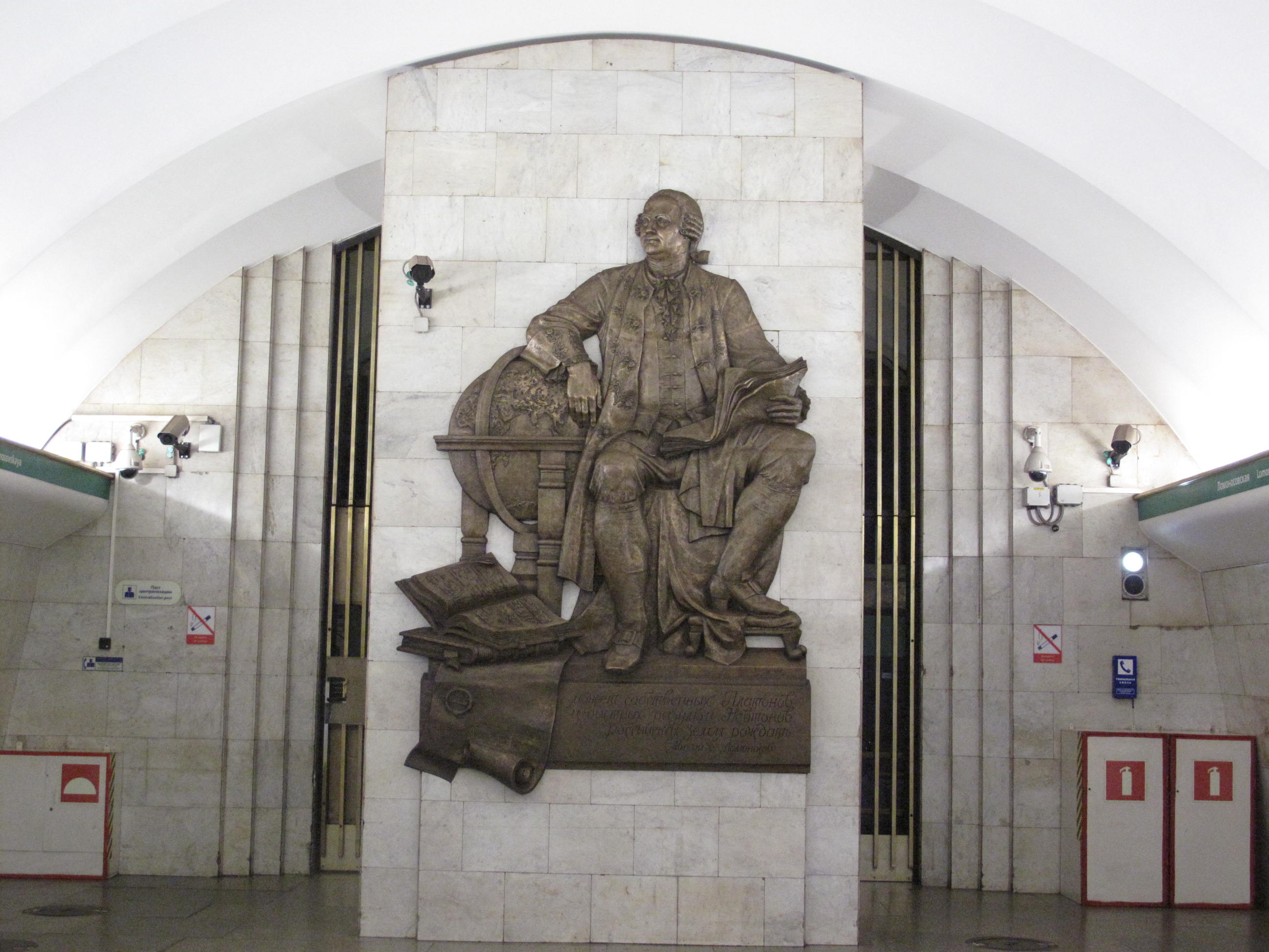 Метро ломоносовская санкт петербург. Станция метро Ломоносовская в Санкт-Петербурге. Станция метро Ломоносовская Санкт-Петербург барельеф Ломоносова. Ломоносова станция метро СПБ. Скульптура Ломоносова на станции метро Ломоносовская.