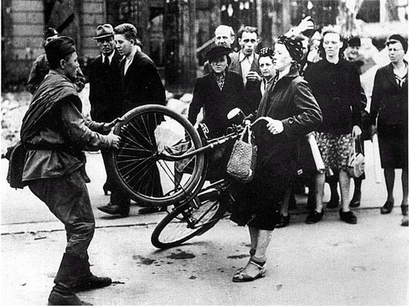 Советский солдат отбирает велосипед у жительницы Берлина