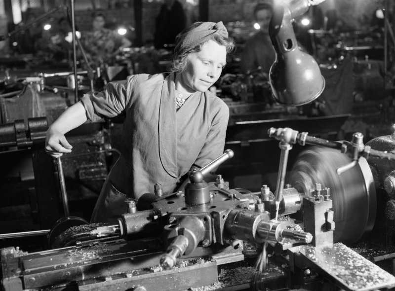 Женщина у станка на заводе