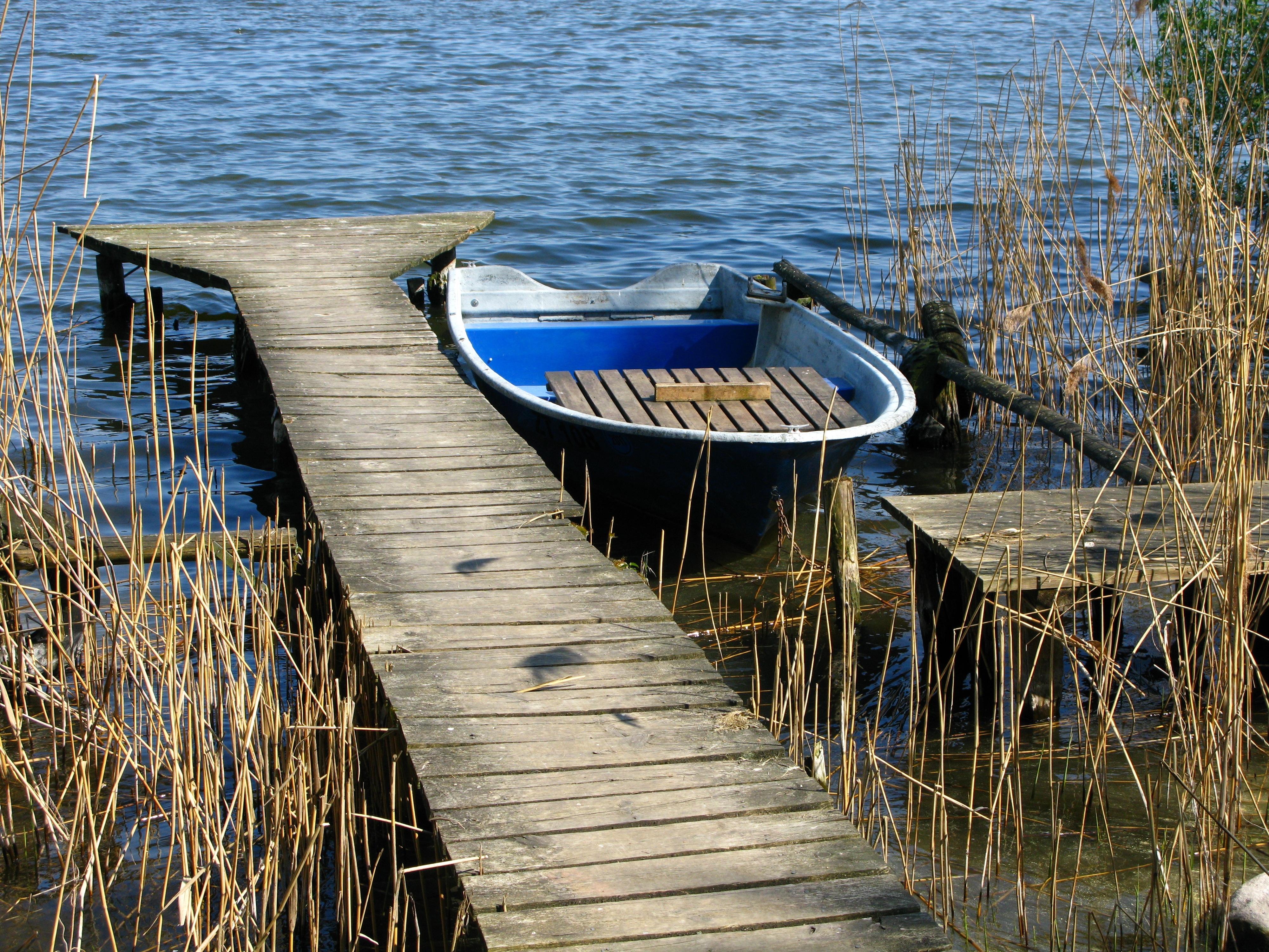 От двух причалов на реке. Причал для лодок. Деревянные мостки на реке. Причал на озере. Пристань для лодок.