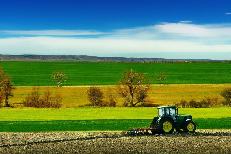 Трактор John Deere на зеленом поле