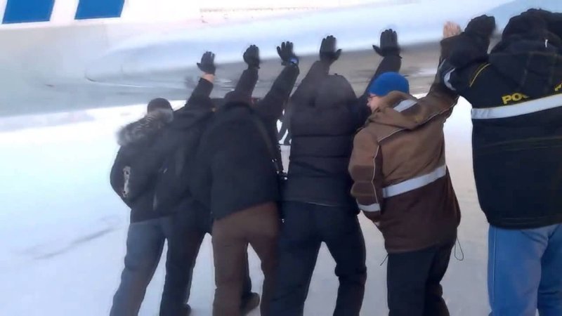 Пассажиры толкают самолет в Игарке